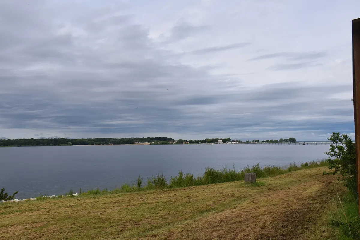 Le lac du Der-Chantecoq vu depuis la digue, avec la rive d'en face et la passerelle au loin